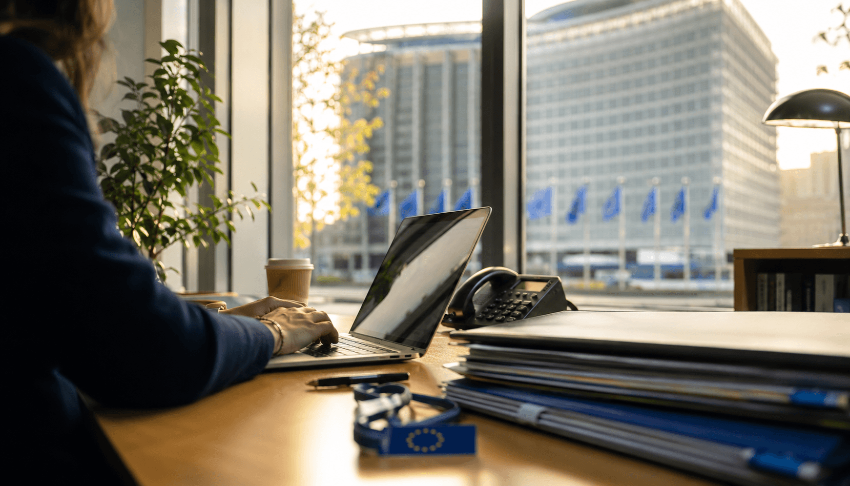 Un professionista che lavora alla scrivania all'interno di un moderno edificio delle istituzioni UE